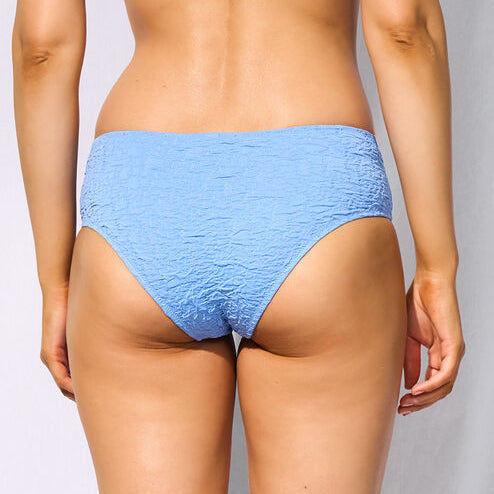 A woman shown from the back wearing a light blue textured two-piece bikini against a white studio background.