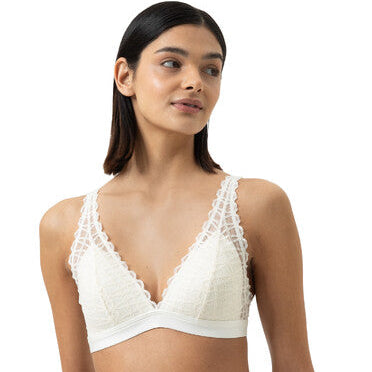 Woman wearing a white lace bra and panties set on a white background