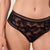 Black lace underwear worn by a person on a plain background
