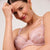 Woman wearing a pink lace bra against a plain background