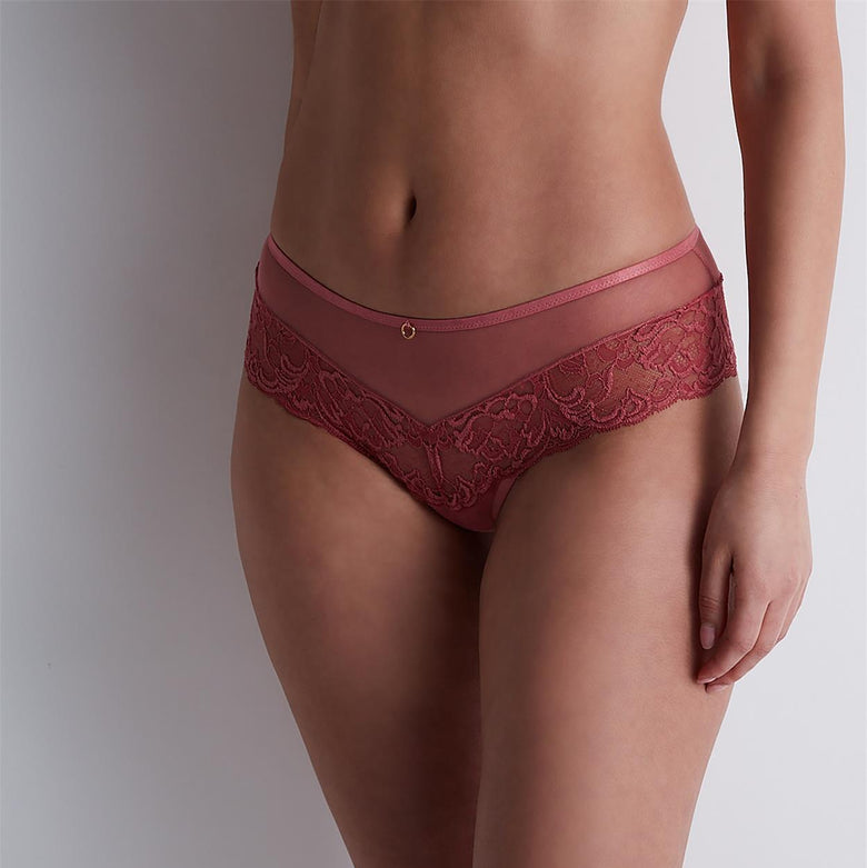 Red lace underwear worn by a person on a plain background