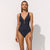 Woman wearing a navy blue swimsuit on a white background