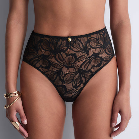 Black lace underwear worn by a model on a neutral background