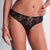 Black lace underwear worn by a person on a plain background
