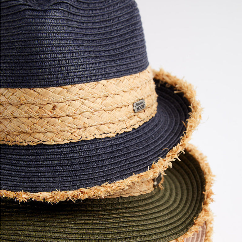 Stack of straw hats in various colors on a white background