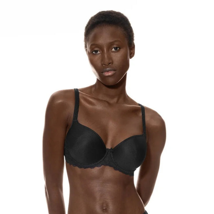 Model wearing a black bra and panties set on a white background