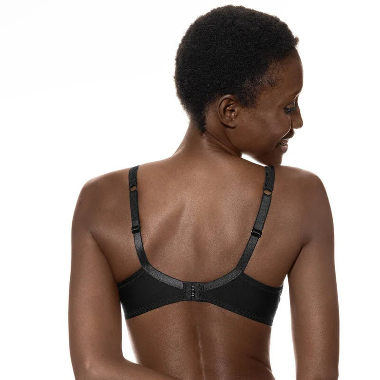 Woman wearing a black bra and underwear set on a white background