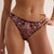 A close-up of a model wearing a pair of sheer floral lace bikini bottoms in a deep burgundy color with pink, gold, and green embroidered details.