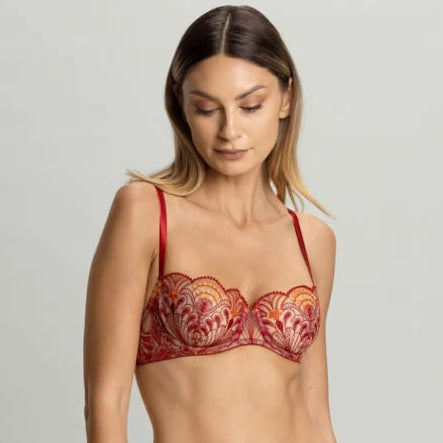 Woman wearing a red lace lingerie set on a gray background