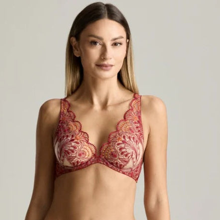 Woman wearing a red lace lingerie set against a neutral background