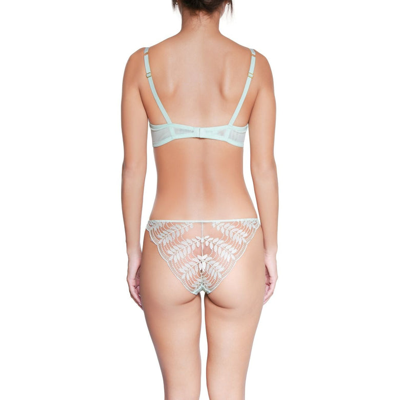 Rear view of a model wearing a light mint green and white lace lingerie set against a plain white background.