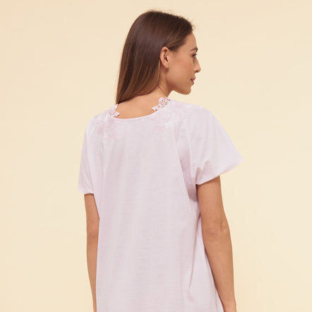 Woman wearing a white nightgown against a beige background