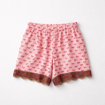Pink shorts with bow pattern and lace trim on a white background