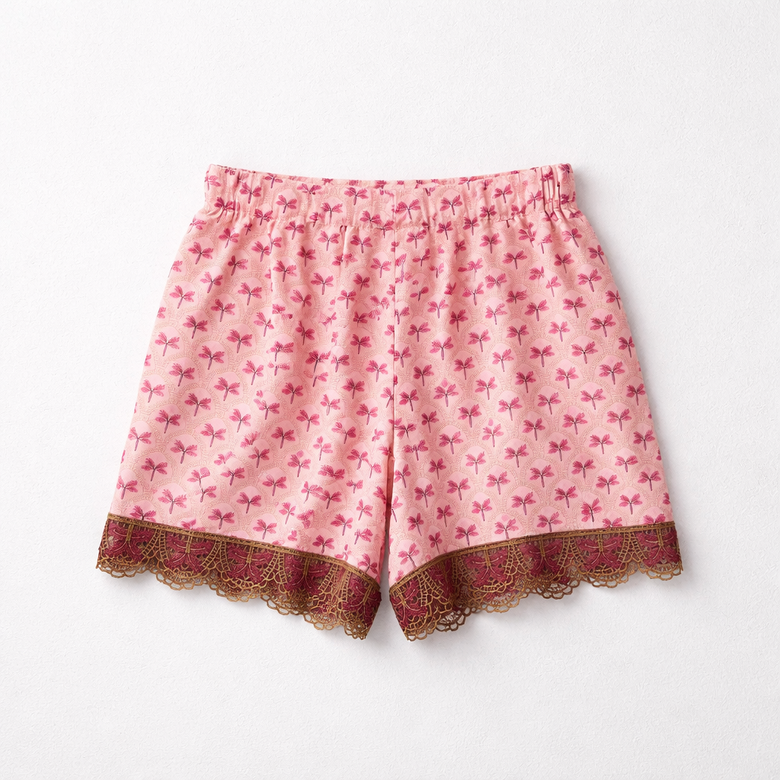 Pink shorts with bow pattern and lace trim on a white background