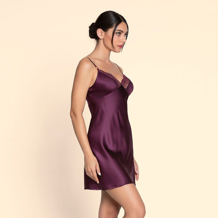 Woman wearing a purple satin nightgown on a beige background