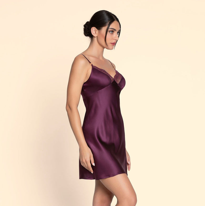 Woman wearing a purple satin nightgown on a beige background