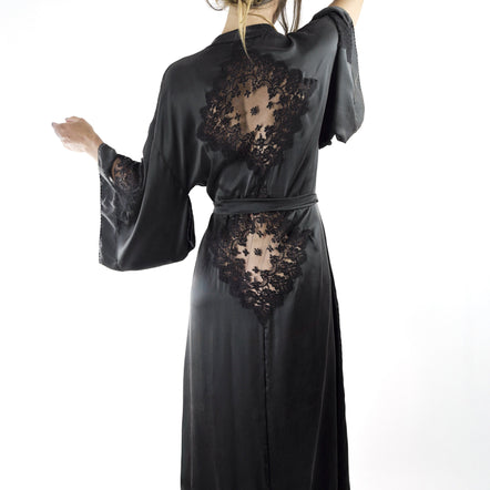 Black satin robe with lace detailing worn by a model on a white background