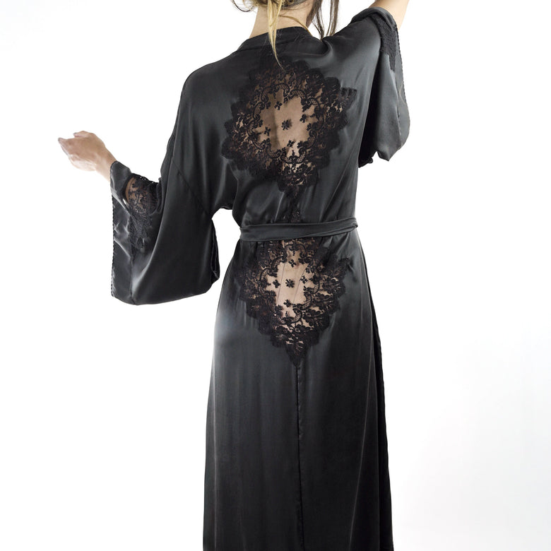Black satin robe with lace detailing worn by a model on a white background