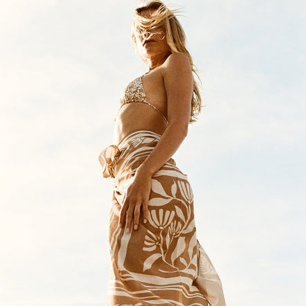 Woman wearing a patterned skirt with a clear sky background