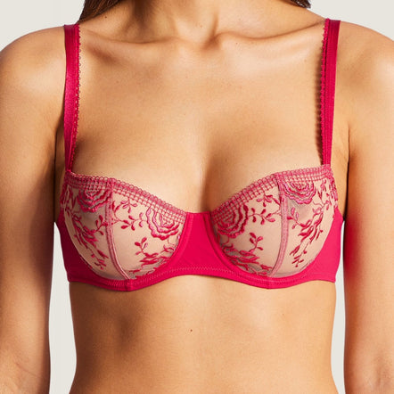 Red lace bra worn by a model on a plain background
