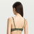 A woman shown from the back wearing a matching two-piece lingerie set in olive green, consisting of a sheer mesh bralette and high-cut briefs, against a plain light gray studio background.