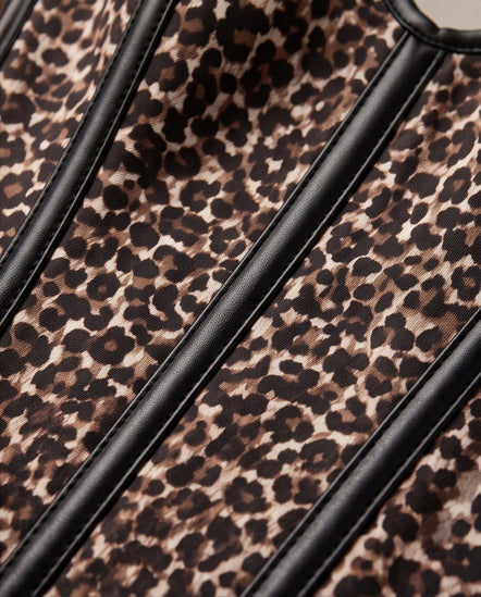 Close-up of a leopard print fabric with black leather-like trim running diagonally across the frame.