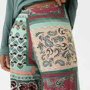 Person wearing a patterned outfit with a focus on colorful pants.