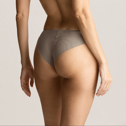 Woman wearing a gray bra and underwear set on a plain background