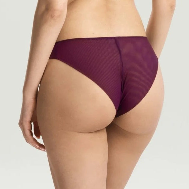 A woman shown from the back wearing a matching deep purple mesh and satin lingerie set against a light gray studio background.