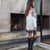 Woman standing in front of a modern fireplace with a glass door.