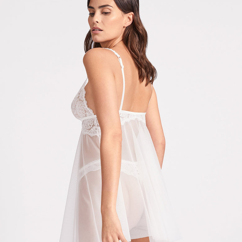 The Aubade Pour Toujours Bridal Babydoll seductively skims the body with draped voile that is open at the front. A small elasticated picot trim adds a vintage feel, whilst transparent tulle contrasts with romantic Cornely embroidery.